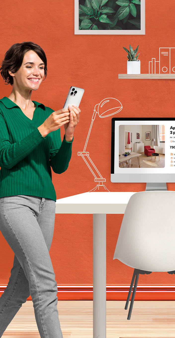 Femme souriante consultant son téléphone devant un bureau avec un écran
d’ordinateur affichant une annonce immobilière